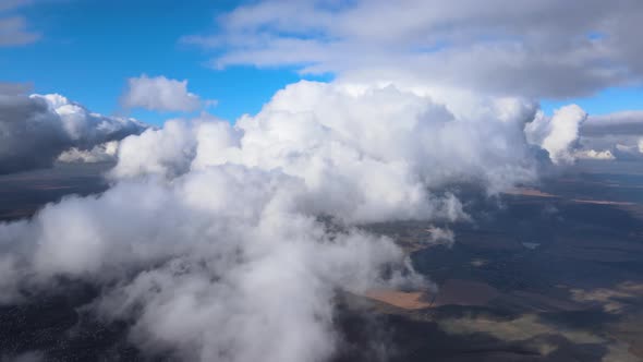 Aerial View From Airplane Window at High Altitude of Earth Covered with Puffy Cumulus Clouds Forming alt