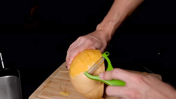 Locked Off View Of Holding Butternut Pumpkin And Peeling Skin With Vegetable Peeler alt