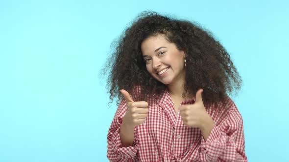Slowmo of Cheerful Caucasian Woman with Curly Dark Hair Dancing with Thumbs Up and Smiling Praising