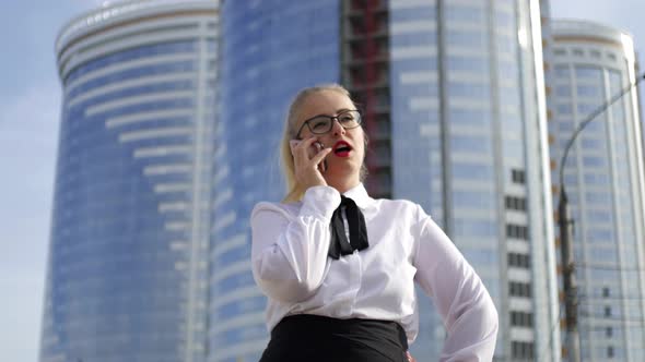 business woman talking on the phone on the background of skyscrapers