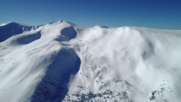 Flight Over the Turquoise Snowy Mountains Illuminated By the Day Sun alt