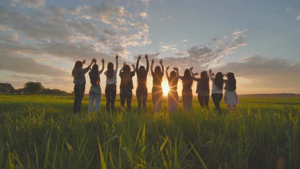 Silhouette of Friends of 11 Girls Waving Their Hands at Sunset in the ...