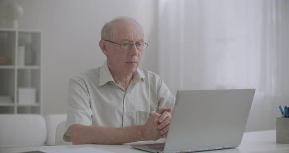 Elderly Man Is Using Online Consultation with Specialist By Laptop with Internet, Staying at Home alt