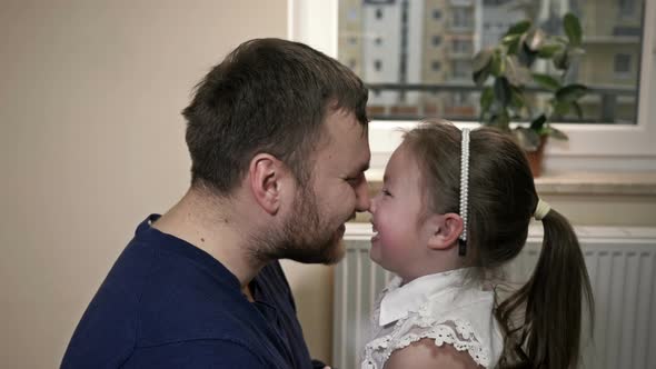 Young Man Plays with His Little Daughter alt