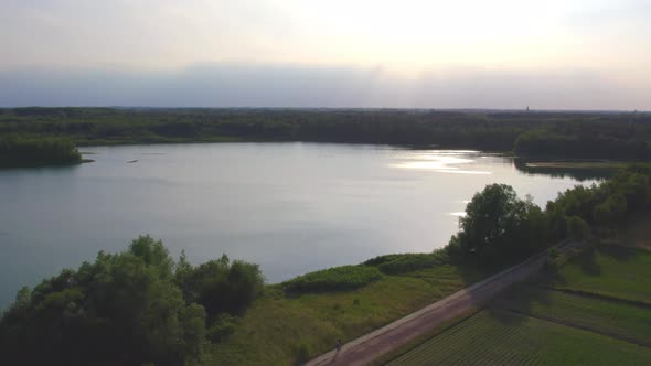 Countryside Dramatic and Colorful Sunset Flight Over a Forest Lake Aerial Shot on a Drone alt