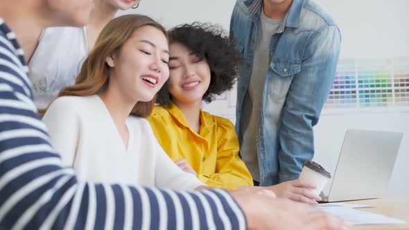 Handheld slow footage of Group of asian young creative happy entrepreneurs in a business meeting. alt