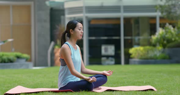 Woman do yoga at the park alt