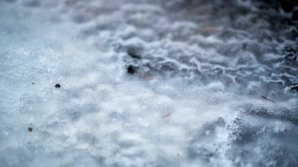 Air bubbles are carried by a stream of water under the ice. Abstraction.