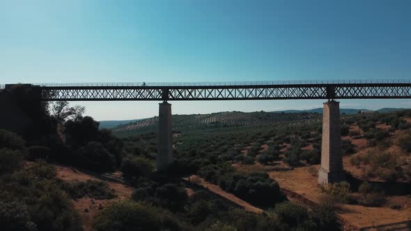 Aerial view cyclist on metal bridge in andalucia Cabra Santo Cristo sunny day alt