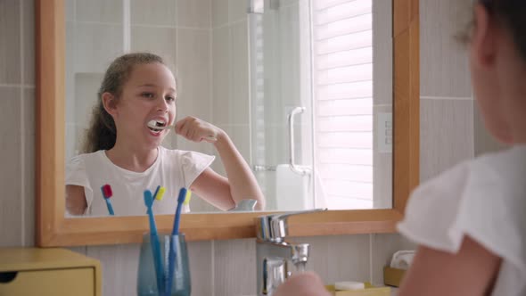Portrait Happy Cute Young Teenage Girl Brushing Teeth in Bathroom and Smiling alt