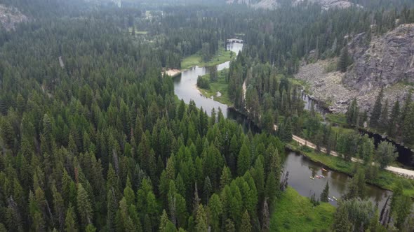 Overhead drone shot of the winding Payette River in the Idaho wilderness as people kayak. This 4K ci alt
