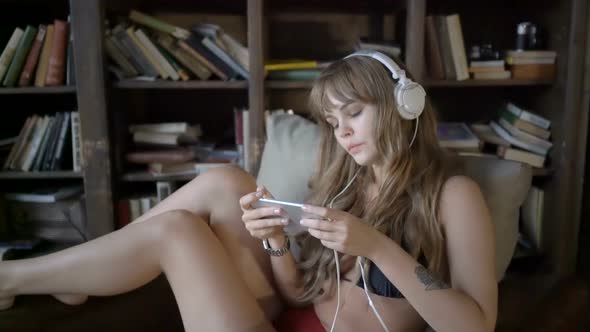 Girl in Headphones is Listening to Music 