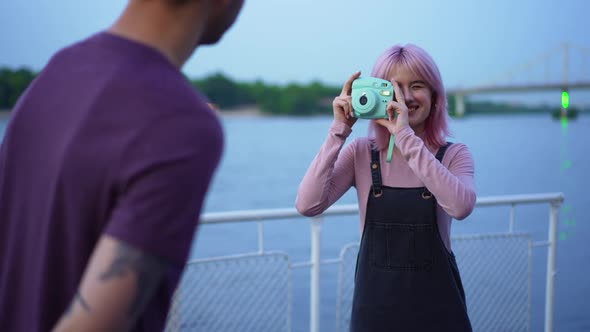 Portrait of Cheerful Caucasian Talented Girlfriend Taking Photo on Camera Smiling As Boyfriend alt