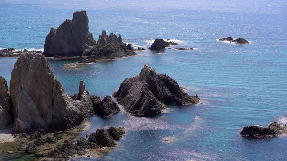 People bathing at Las Sirenas bay, Cabo De Gata, Almeria. Zoom in alt