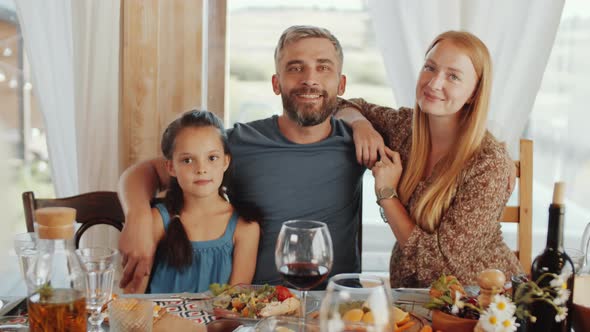 Beautiful Parents and Little Daughter Posing for Camera at Family Dinner alt