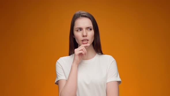 Young Woman Thinking About Her Problem Came Up with the Idea Against Yellow Background alt