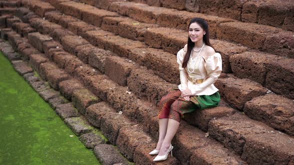 slow motion of happy beautiful woman in Thai traditional dress near the pond alt