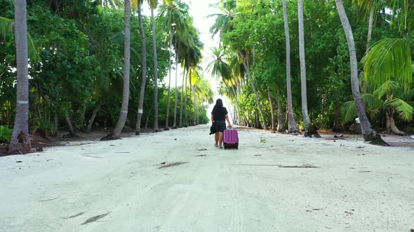 Single female relaxing on tropical coast beach lifestyle by blue green lagoon and white sand backgro alt