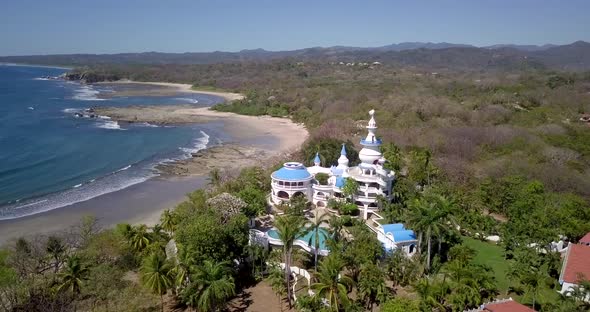 Aerial drone view of the beach, rocks and tide pools in Guiones, Nosara, Costa Rica. alt
