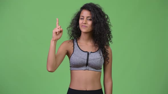 Young Beautiful Hispanic Woman with Gym Clothes Pointing Up alt
