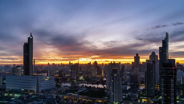 Sun rise over Bangkok business district, night to day, tilt up - Time Lapse