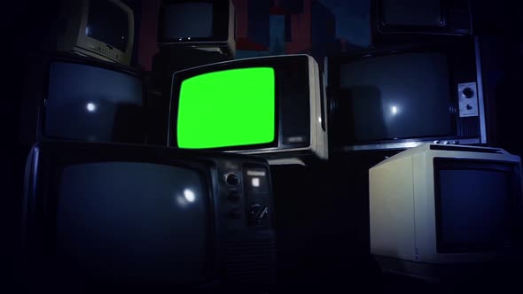 Retro TV Green Screen Amid Many Piled Television. Dark Tone. Zoom Out. alt
