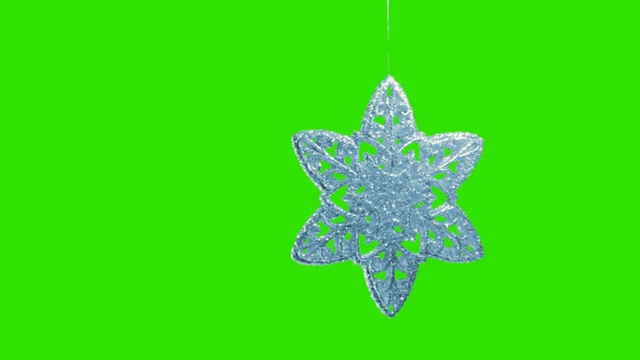 Ornament in the Form of a Snowflake on a Green Background alt