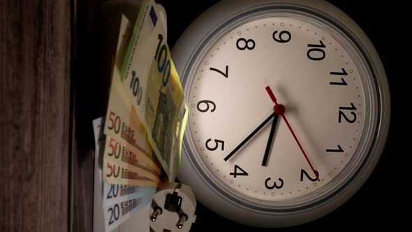 Closeup Shot of Currency and a Socket with a Clock Behind Them alt