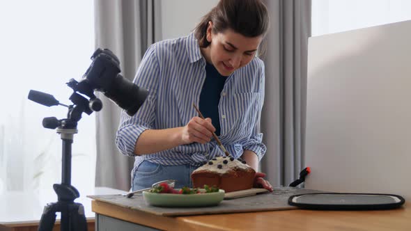 Food Blogger with Camera Working Cake in Kitchen