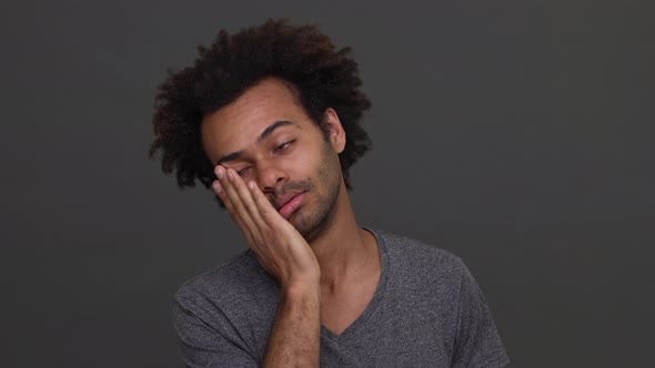 Dark Skinned Young Man with Afro Haircut Trying to Wake Himself Up Slapping on His Cheek Isolated alt