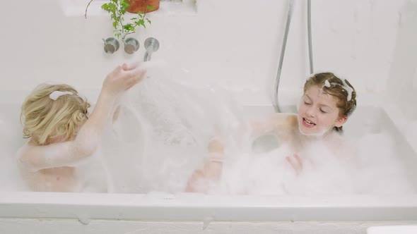 Kids Splashing Water And Soap Suds From Bath alt