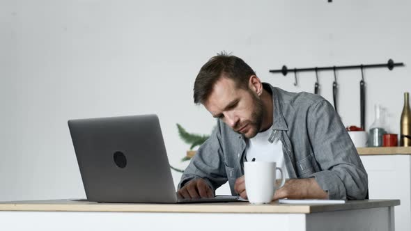 A Young Male Freelancer Makes Notes in A Magazine, A Freelancer Works At Home alt