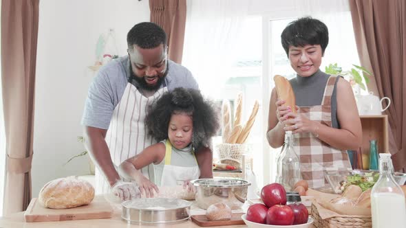 Joyful African American family enjoying dancing and cooking together
