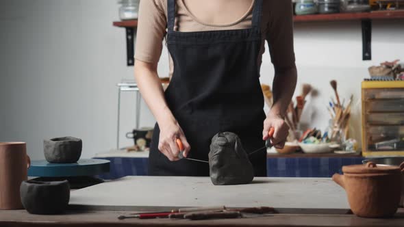 Woman using wire cut with clay alt