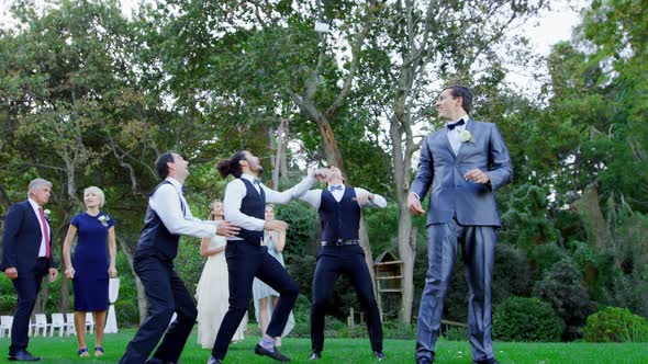 Garter toss by happy groom and groomsmen catch it 4K 4k alt