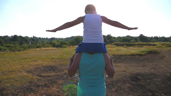 Father and Son Playing on Summer Field at Sunny Day alt