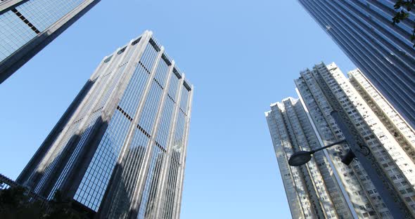 Low angle shot of camera rotating in front of skyscrapers alt