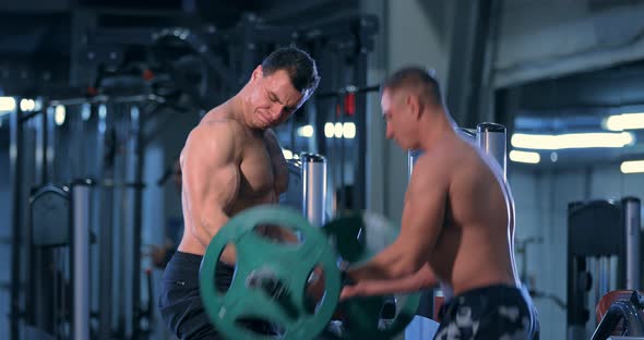 Bodybuilder Doing an Exercise with a Barbell in the Gym