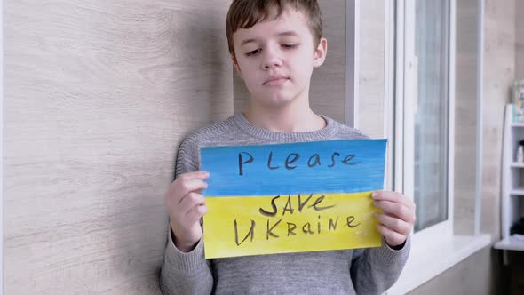 Child Holds a Banner with a Blue and Yellow Flag Message Please Save Ukraine alt