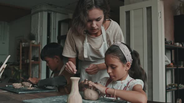 Woman Helping Girl on Pottery Lesson alt