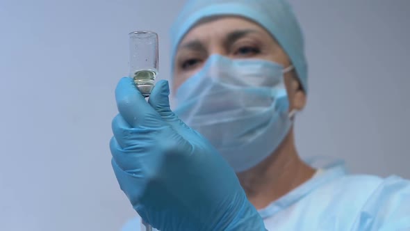 Female Medical Worker in Protective Uniform Preparing Injection, Vaccination