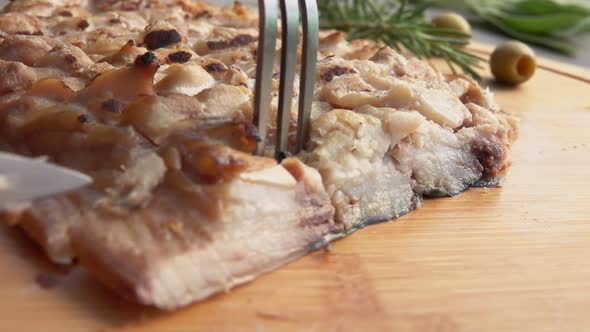 Closeup of a Knife Cutting a Piece of Grilled White Mackerel Fish Fillet alt