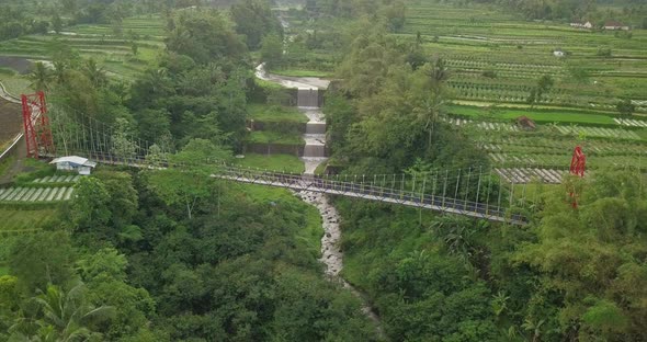 Aerial drone view of suspension bridge, valley and river with waterfalls. mangunsuko bridge or Jokow alt