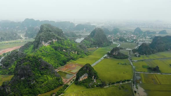 Aerial: North Vietnam karst landscape, drone view of Ninh Binh canyons and pinnacles alt