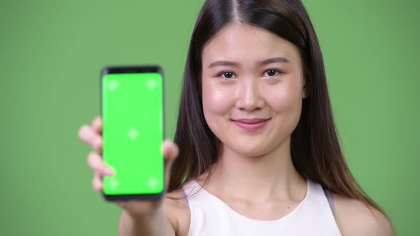 Young Beautiful Asian Businesswoman Showing Phone
