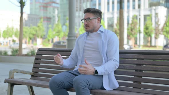 Tense Man Feeling Frustrated While Sitting Outdoor on Bench alt