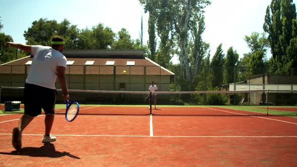 Anonymous Men Playing Tennis on Court in Summer