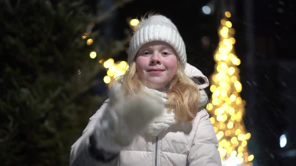 Beautiful Slow Motion Video, a Blonde Girl Throws Snow at the Camera