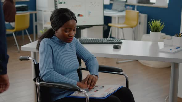 African Woman Employee Looking at Camera Smiling Sitting in Wheelchair alt
