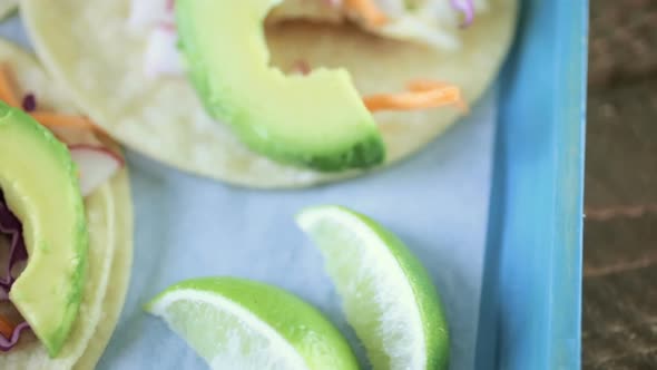 Fresh fish tacos with cod and purple cabbage on a white corn tortillas. alt